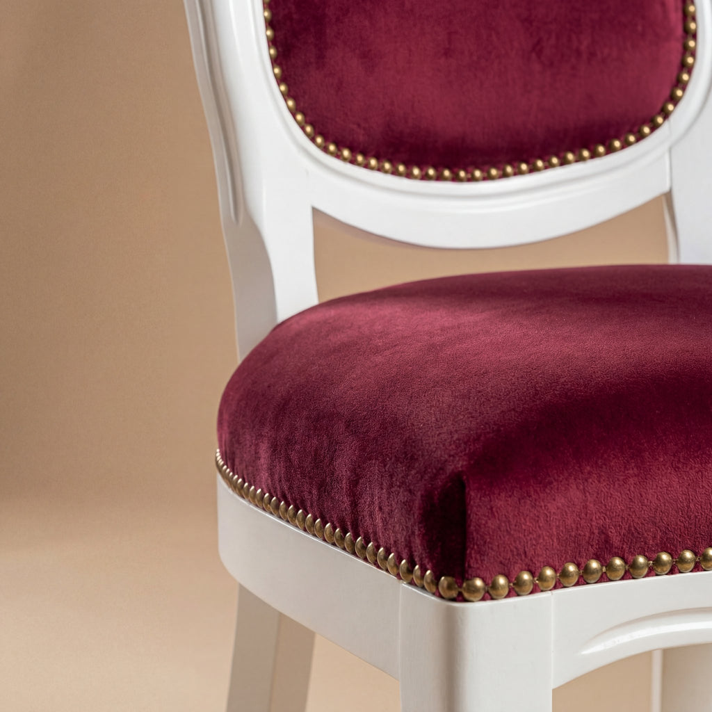 Close-up of antique brass nailheads on burgundy velvet seat of the Venezia chair.